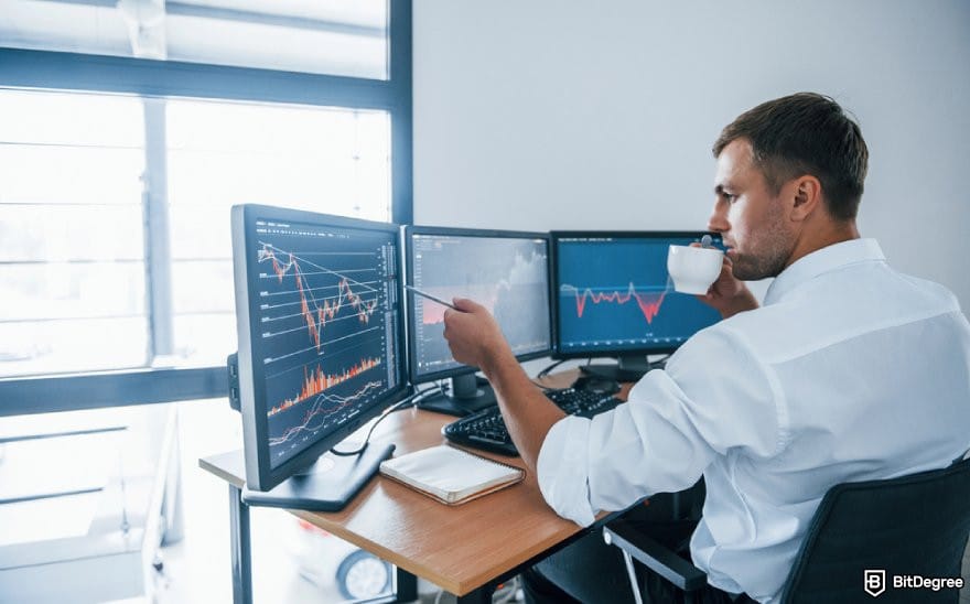 Binance review: a person looking at charts on multiple monitors.