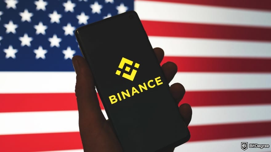 Binance taxes: Binance logo displayed on a phone in front of a US flag.