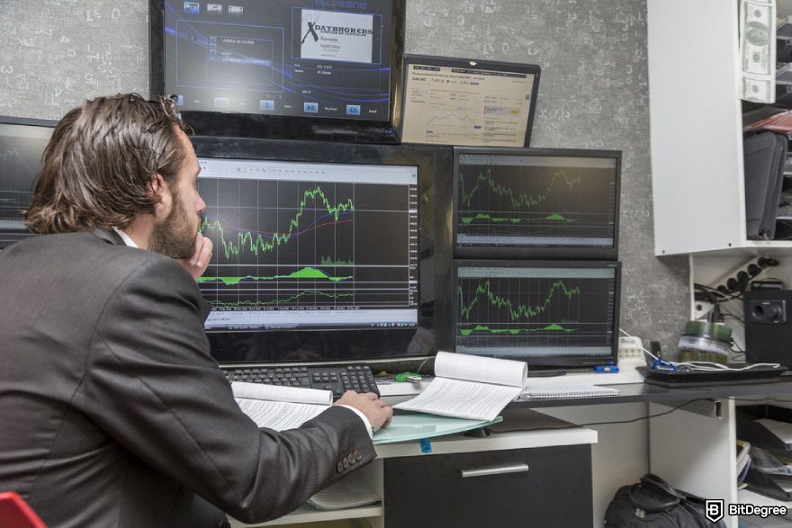 Bitcoin cycles: a day trader in front of several monitors.