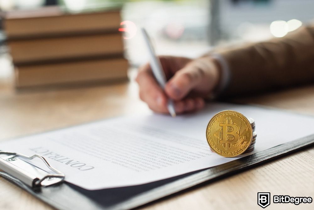 Bitcoin scams: a businessman signing contract near Bitcoin.