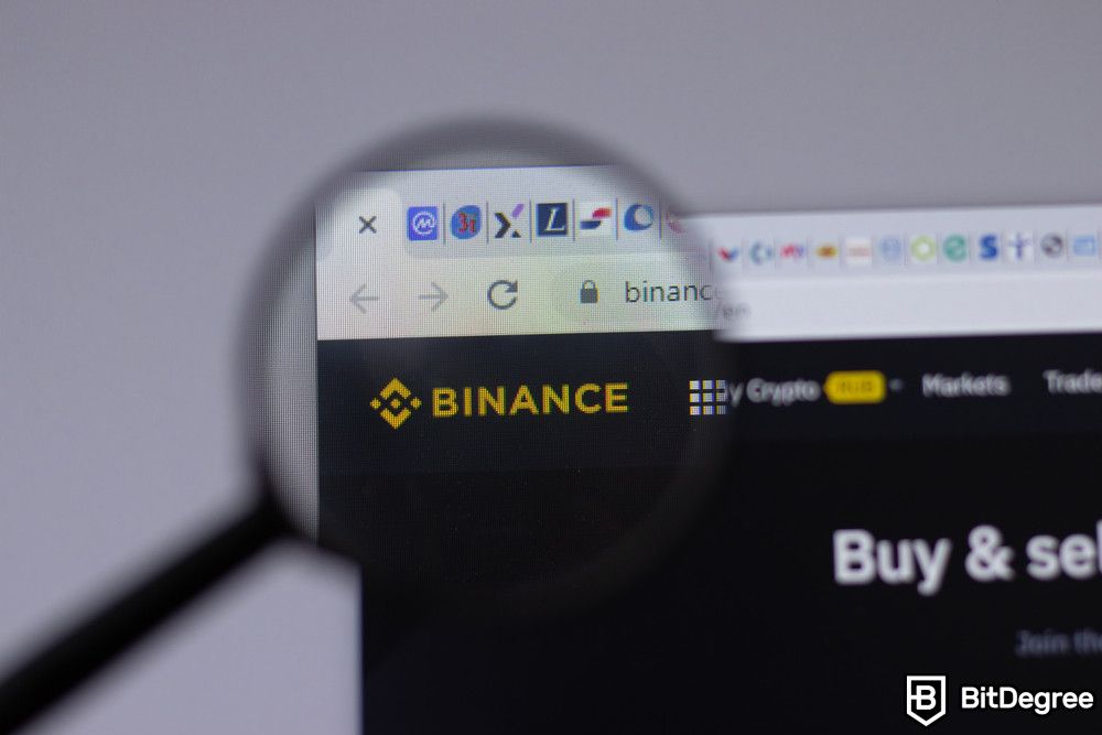 Bitcoin scams: a magnifying glass pointing out the Binance logo.