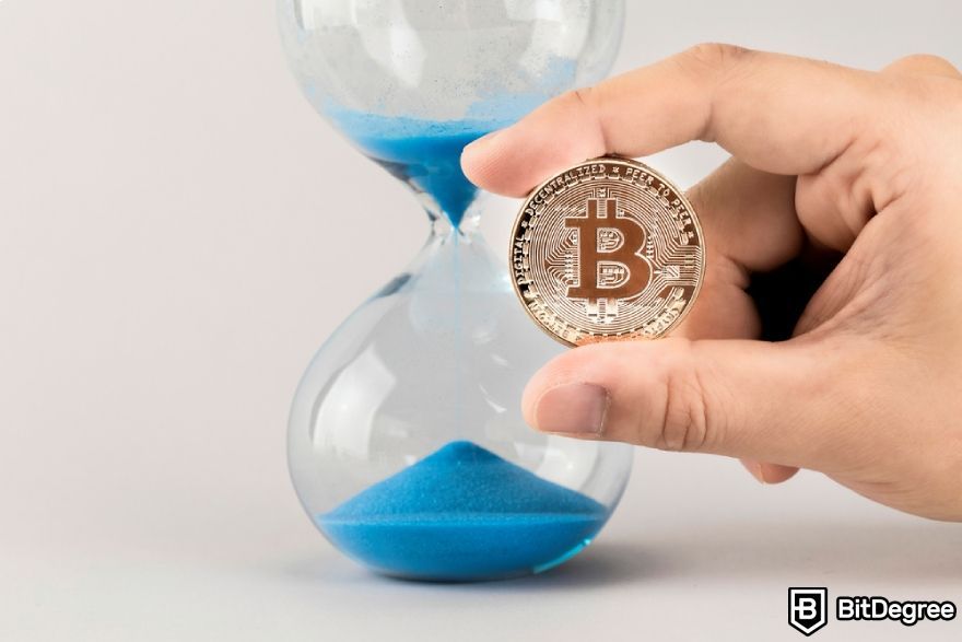 Bitcoin transaction time: Bitcoin next to a sand clock.