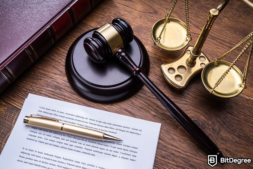 Blockchain accounting: legal concept image with a gavel, scales, and pen on a desk.