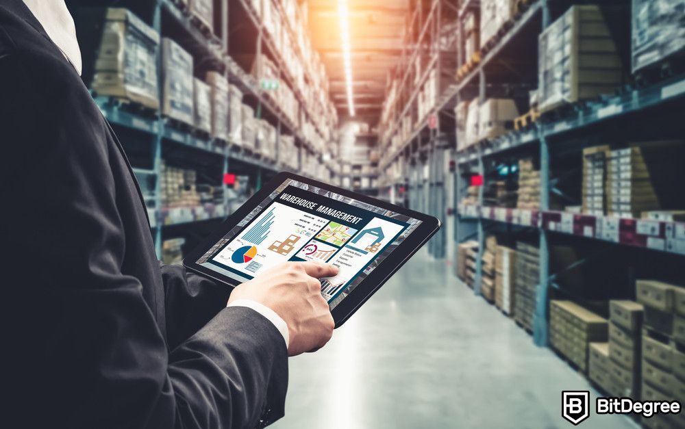 Blockchain for enterprises: a person holding a tablet in a warehouse.