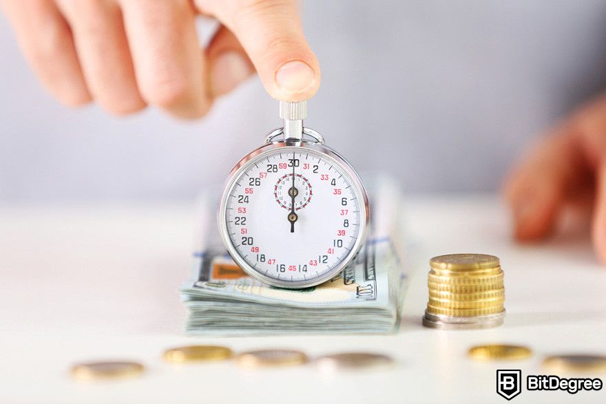 Blockchain in banking: a person holding a stopwatch on top of a stack of money.