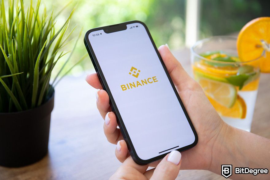 Blockchain trong tài chính: một chiếc điện thoại di động hiển thị logo Binance trên màn hình.