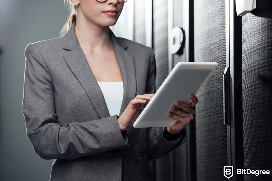 Blockchain in real estate: A woman holding a digital tablet in a server room.