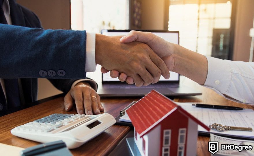 Blockchain in real estate: A home sales agent and buyer shakes hands.