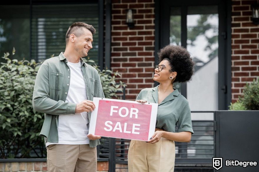 Blockchain in real estate: Real estate brokers standing with a for sale signboard.