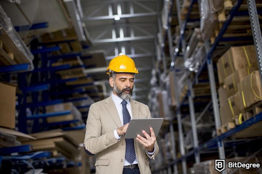 Blockchain in supply chain: A portrait of middle-aged warehouse worker with a digital tablet.