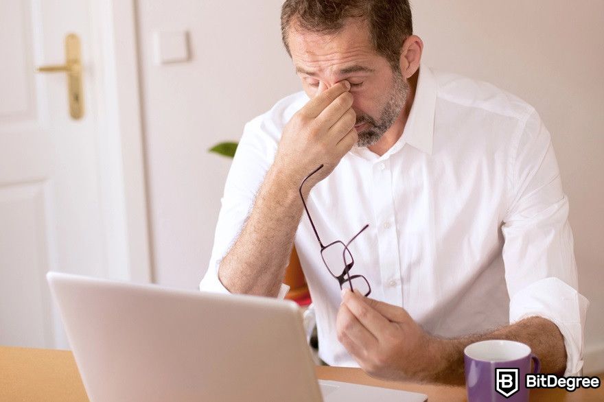 Blockchain marketing: A middle-aged man looking stressed near a laptop.