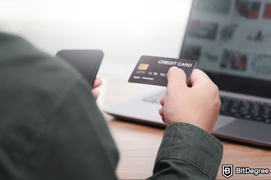 Buy crypto with PayPal: a man holding a credit card.