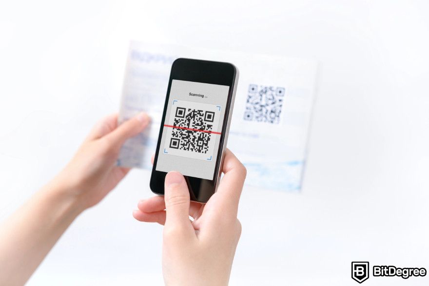 Buy crypto with PayPal: a person scanning a QR code.