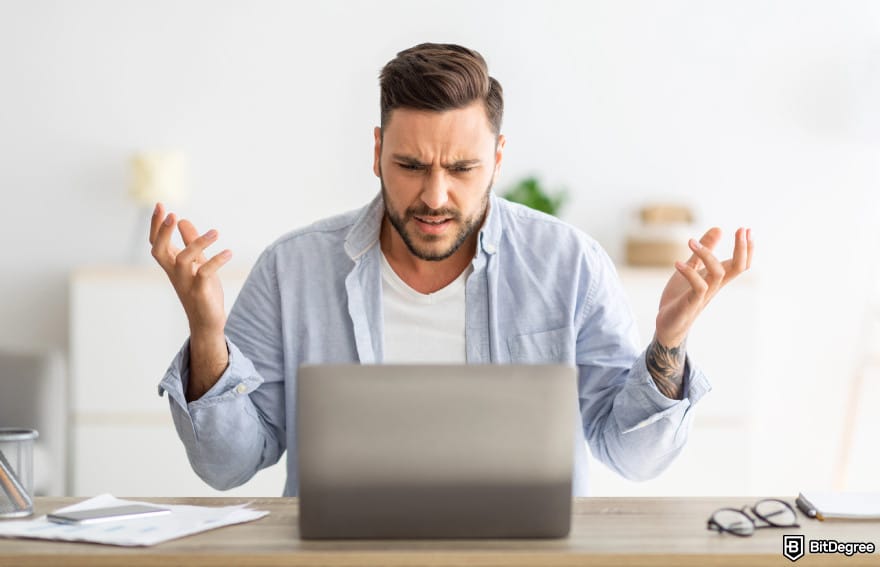 Buy XRP with PayPal: a man in front of a computer looking frustrated to illustrate PayPal's high fees.