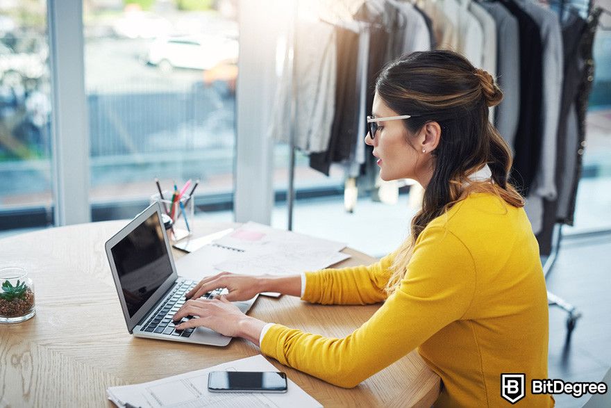 Bybit affiliate: a person using a laptop on a wooden desk.