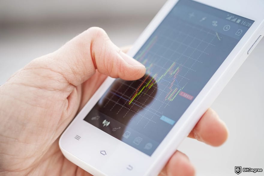 Bybit Earn: a close-up finger hand of a trader touching smartphone screen with trading interface.