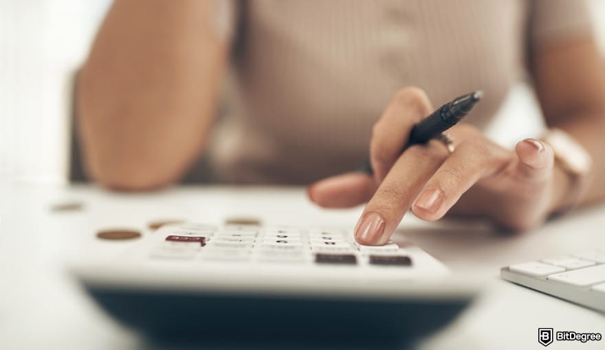 Bybit margin trading: person with a calculator to illustrate crypto fee calculation.