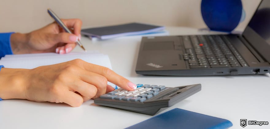 Bybit taxes: a woman writing on paper while using a calculator.