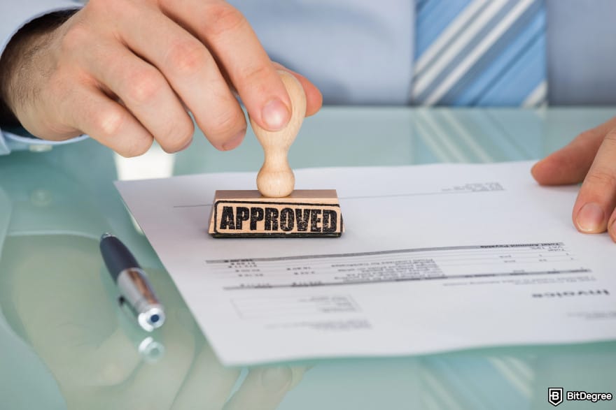 Can you buy crypto on Schwab: a male employee approving a paper with a stamp.