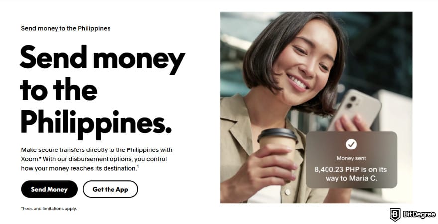 Layanan kirim uang ke Filipina paling murah: wanita tersenyum pada ponsel mengonfirmasi transfer PayPal.