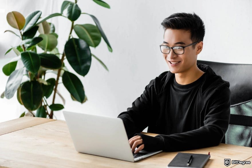 Cluely AI review: a person using a laptop while smiling.