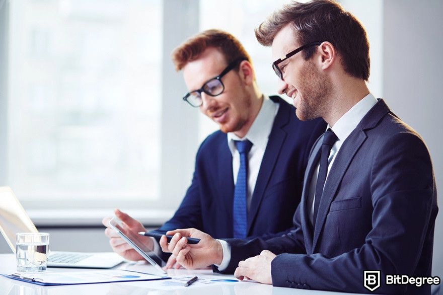 Crypto bear market: two businessmen looking happy at a screen.