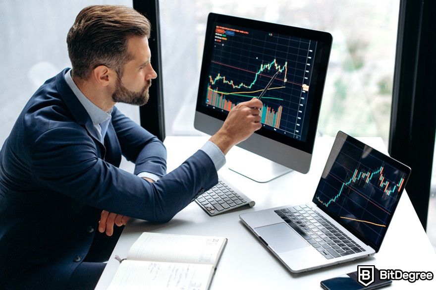 Crypto bear market: a male investor sits and monitors graphics on his screens.