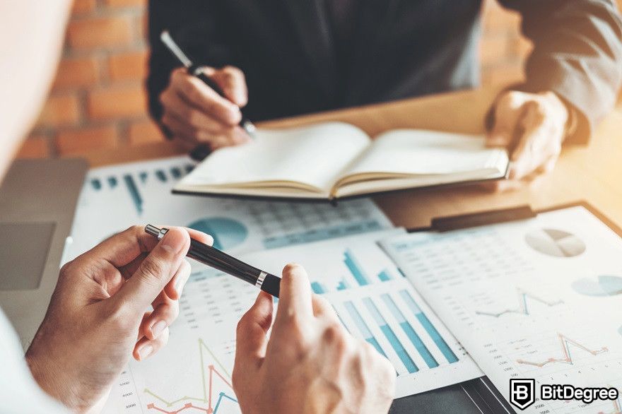 Crypto bear market: two people planning a strategy with documents on a table.