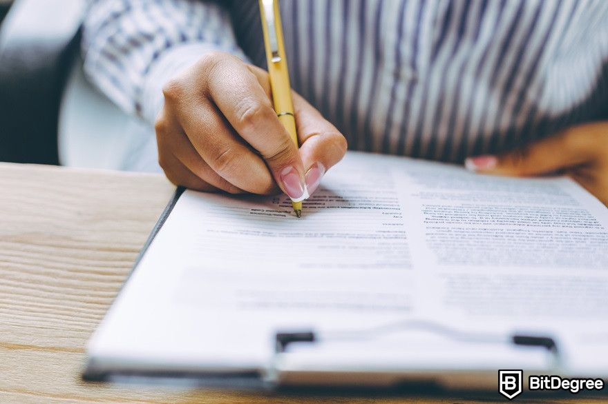 Crypto bear market: cropped-shot of a female hand signing a contract.