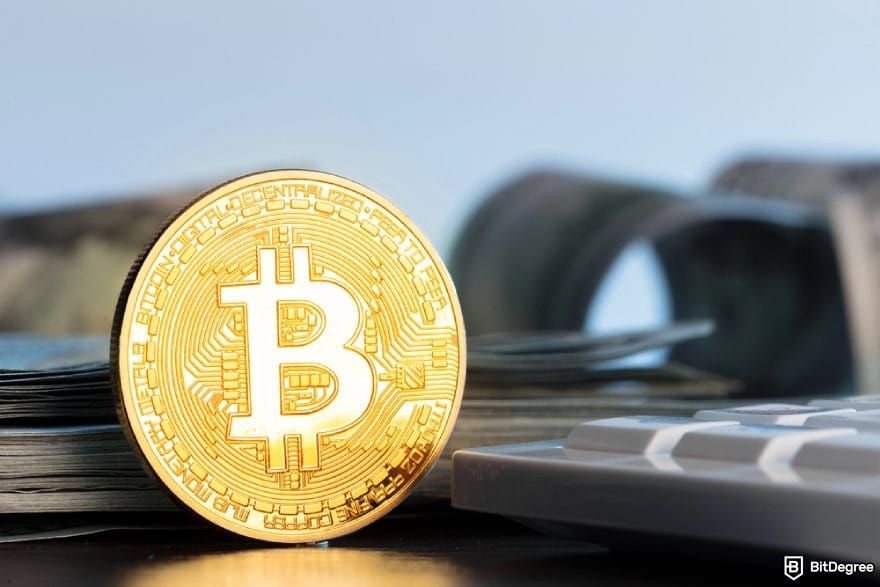 Crypto.com review: a golden BTC coin beside a computer keyboard.
