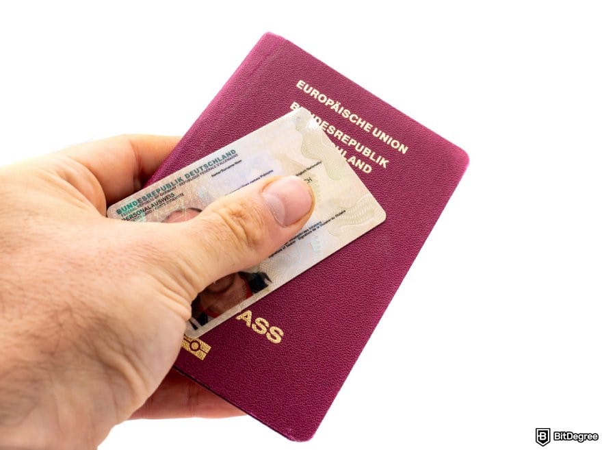 Crypto.com review: a hand holding an ID card and a passport.