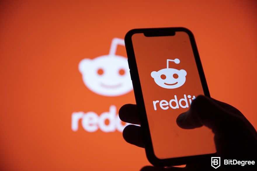 Crypto forums: Reddit logo on a phone screen.