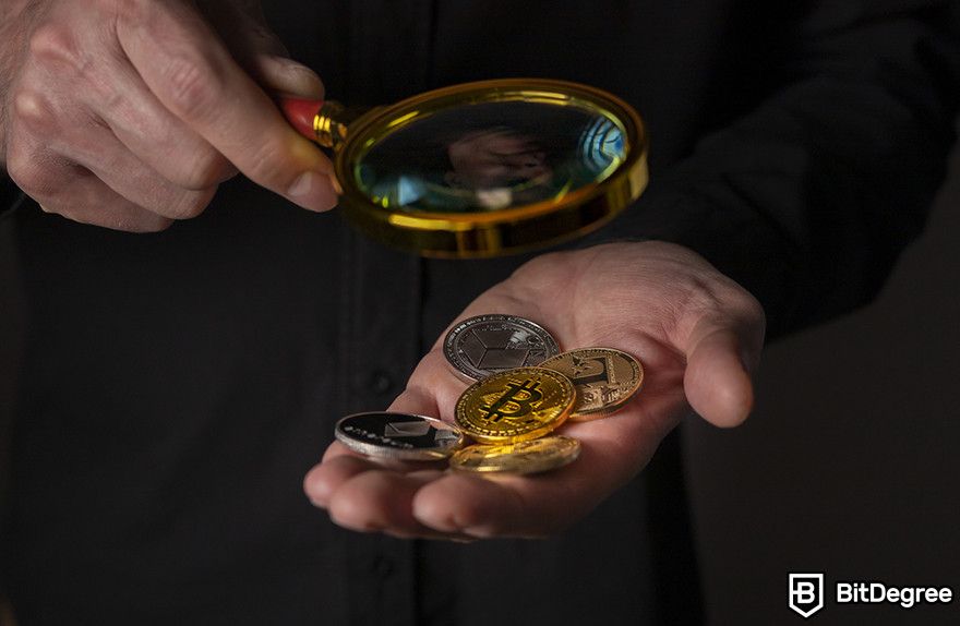 Crypto vs stocks: a person examining multiple crypto coins using a magnifying glass.