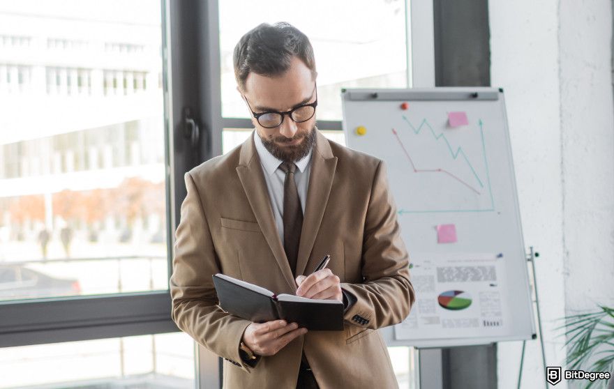 Cryptocurrency jobs: a man taking notes for product management.