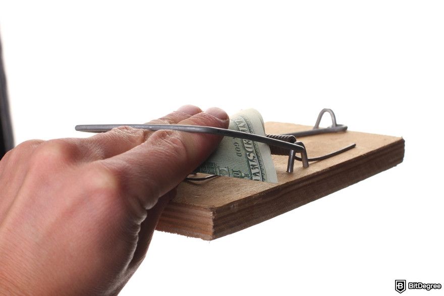 Cryptocurrency security: a person taking money from a mousetrap.