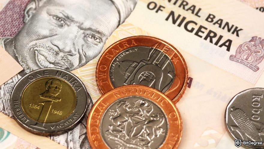 Currency devaluation in Nigeria: close-up of naira banknotes and coins placed on top of each other.