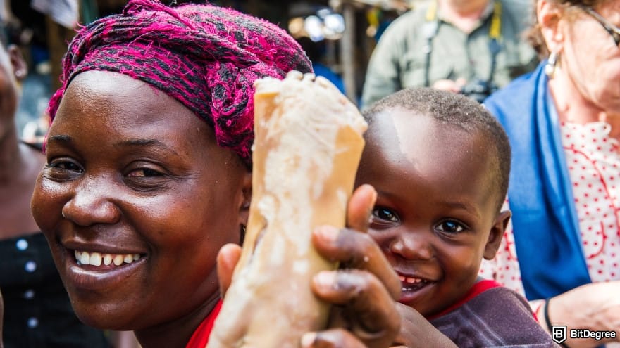 Currency devaluation in Nigeria: smiling woman and child holding food in a busy outdoor market.