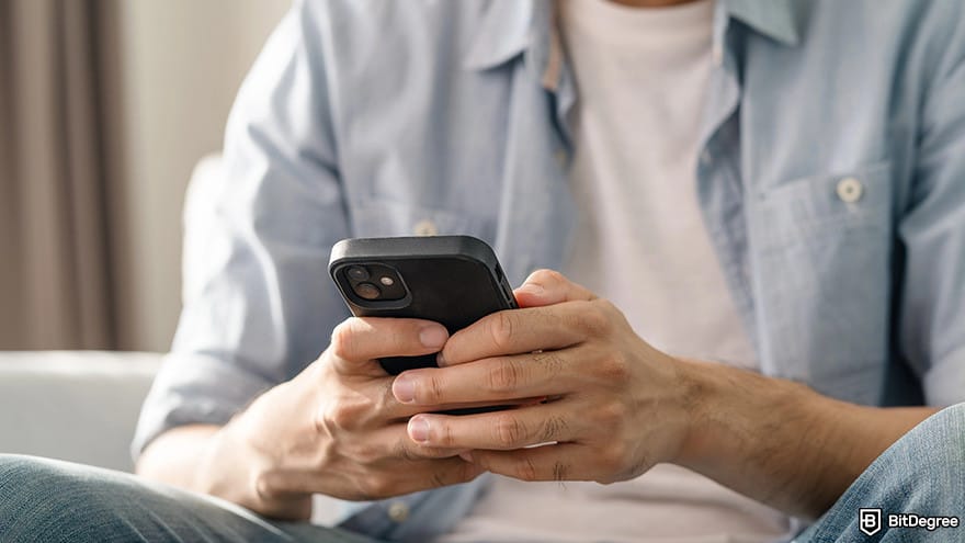 Datacamp vs Coursera: man using a smartphone.