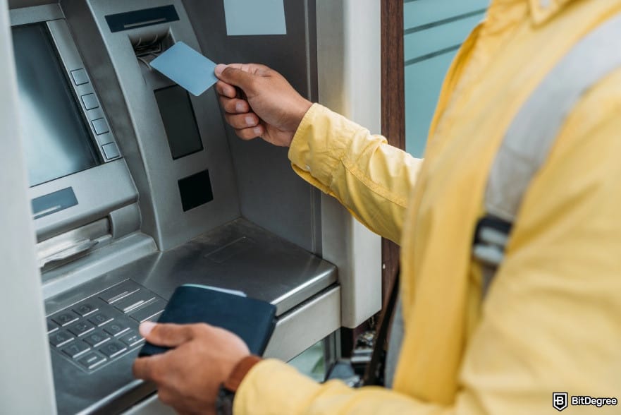 Does Wise work in Nigeria: a person inserting a card into the ATM.