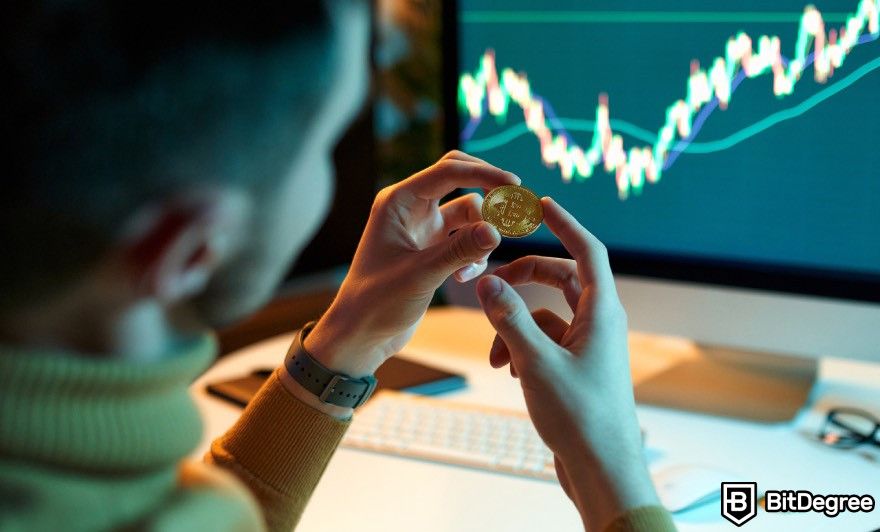 Ethereum cloud mining: A man holding a Bitcoin in front of a computer.