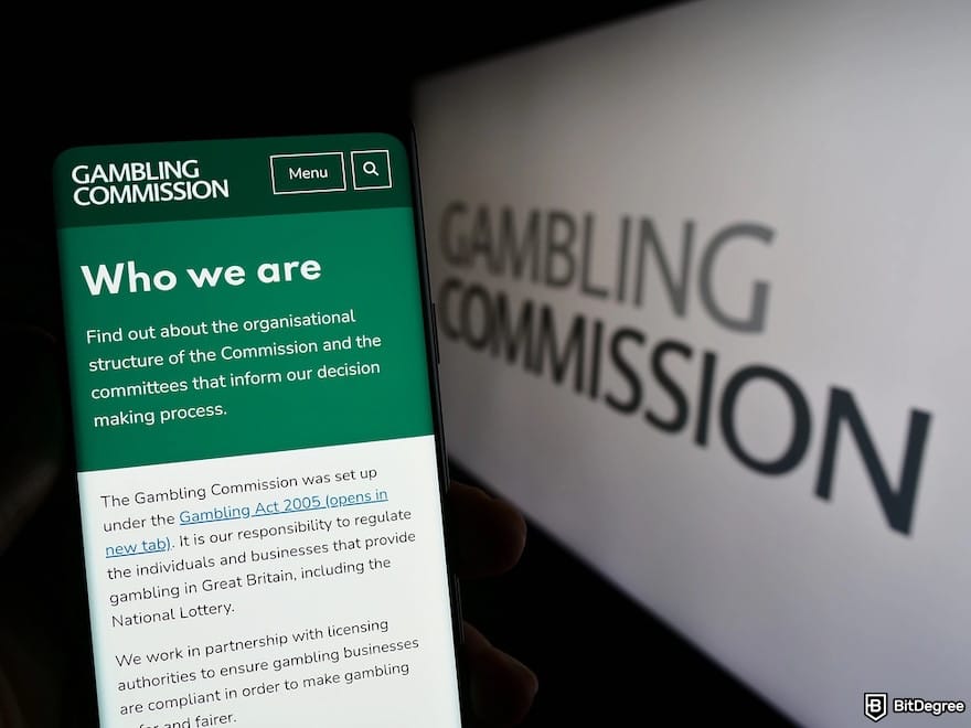Fairspin Casino review: a person holding smartphone with a web page of British Gambling Commission on screen. Fairspin Casino review: a person holding smartphone with a web page of British Gambling Commission on screen.