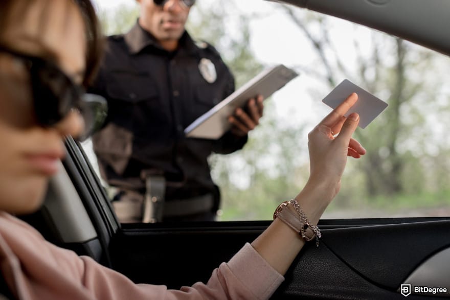 Fidelity Crypto review: a woman showing her driver license to a police officer.