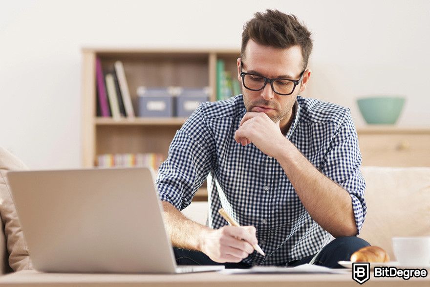 Fractional NFTs: a person taking notes in front of a laptop.