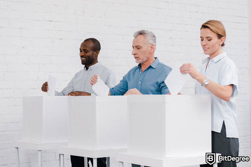 Future of blockchain: three people voting during election.