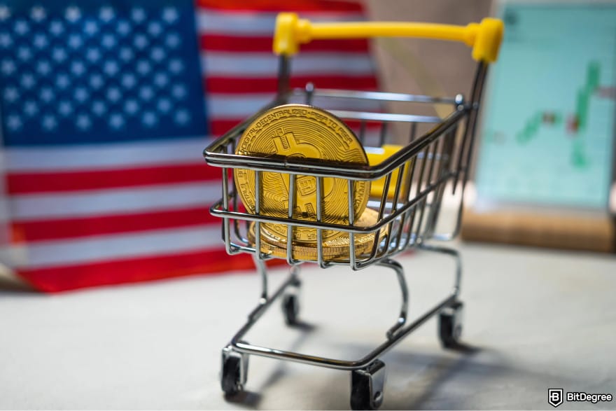 Gemini Credit Card Review: a Bitcoin in a miniature shopping card in front of the American flag.