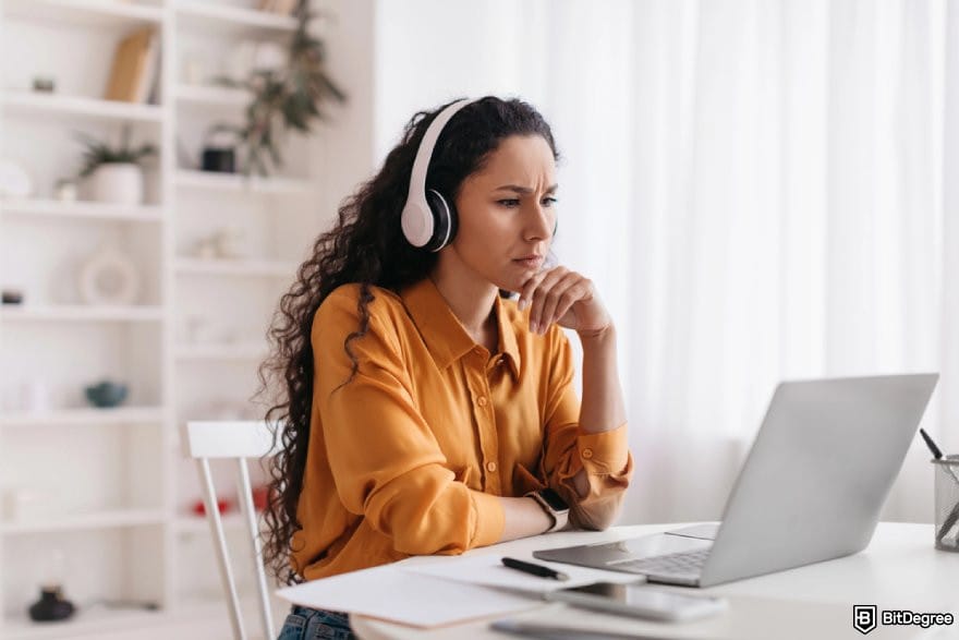 Google Analytics 4 courses: a person looking at a laptop while wearing a pair of headset.