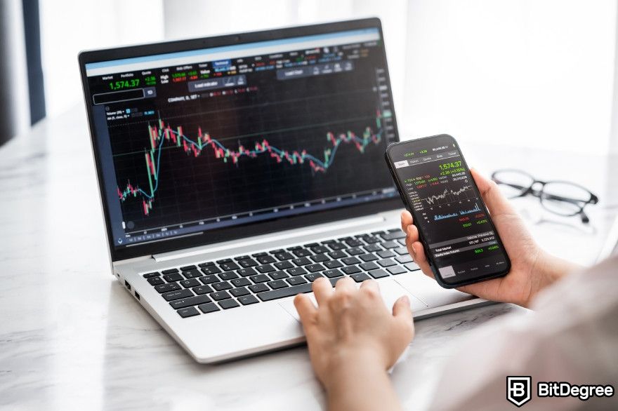 Grid trading bot: a trader looking at charts on a computer and a smartphone.