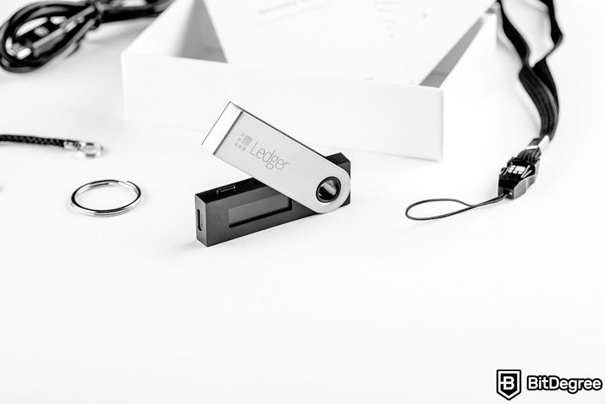 Hard token vs soft token: Ledger's hardware wallet with its accessories on top of a white surface.