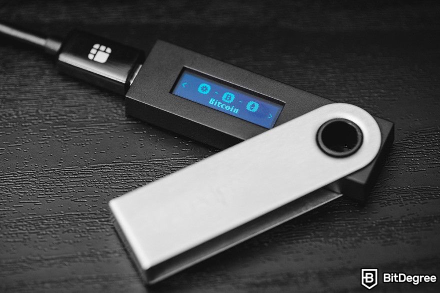 Hardware wallet: a Ledger hardware wallet connected to a USB cable.