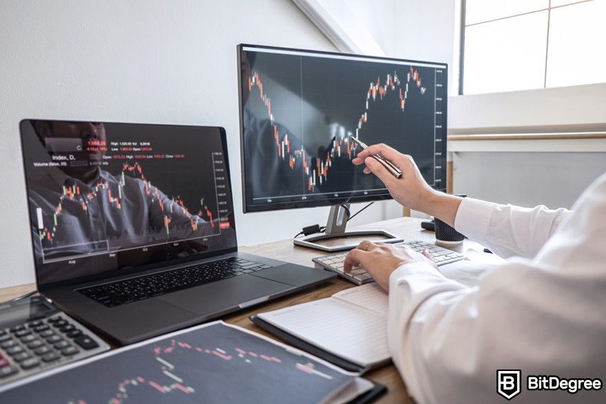 History of cryptocurrency: Investors checking a trading exchange market on computers displaying graphs.